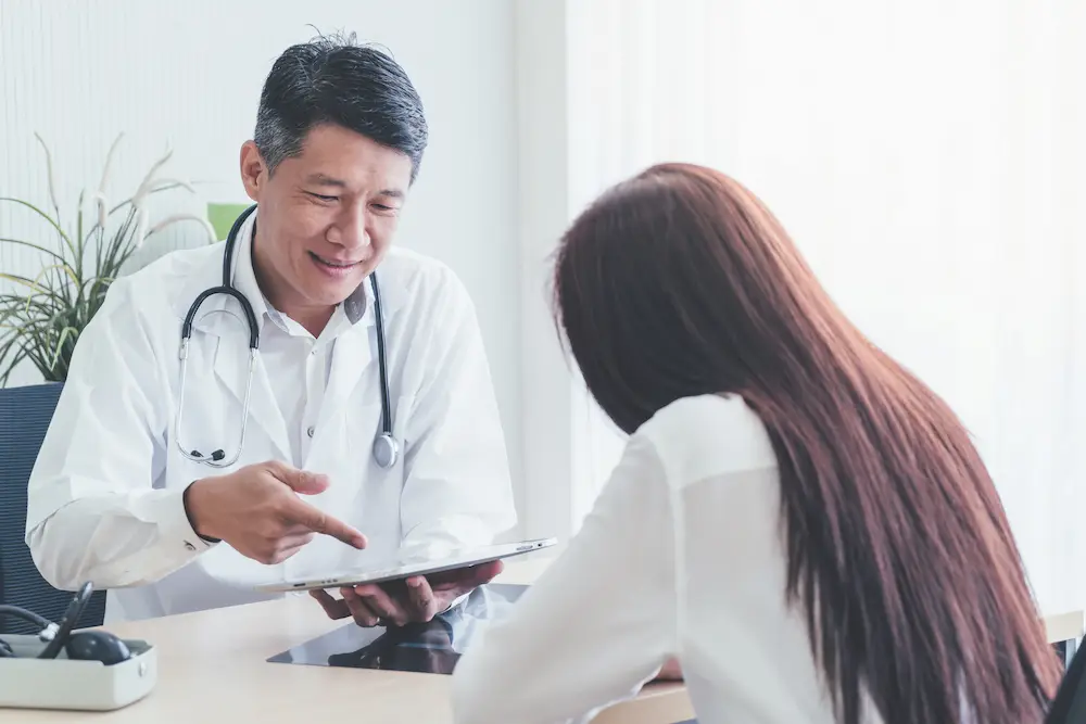 Cancer treatment options consultation showing patient and oncologist reviewing treatment choices together