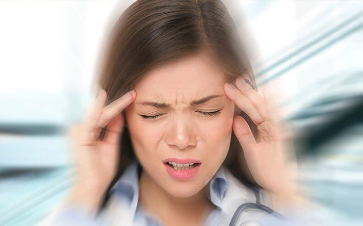 Person holding head due to dizziness, showing the connection between cardiac conditions and lightheadedness in adults