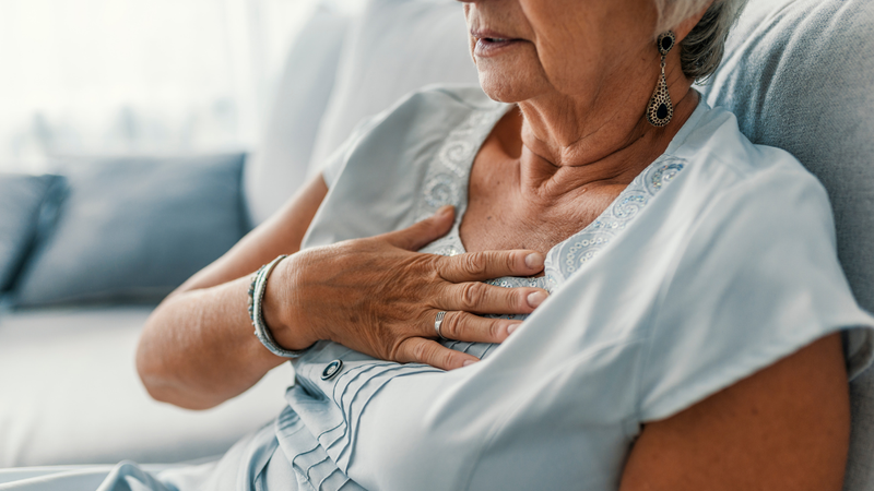 tired woman sitting on bed showing signs of cardiac fatigue from heart disease
