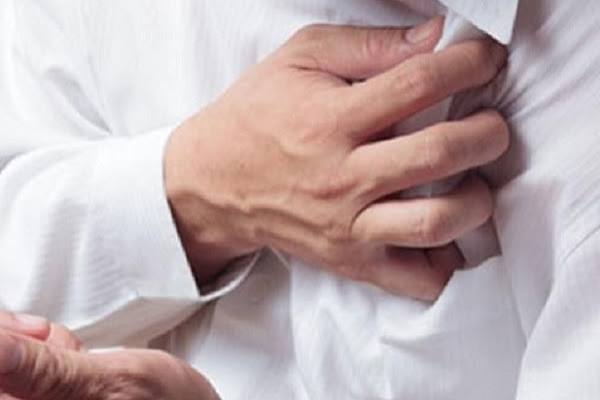 Chronic stress and heart disease — stressed person holding chest representing cardiovascular effects of chronic stress