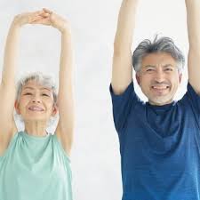 older adult with diabetes doing gentle exercise with a caregiver in a bright senior living environment