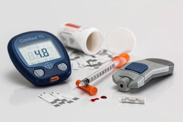 Diabetes medications low blood sugar risk — glucose meter showing hypoglycemia reading with insulin syringe and medication bottles representing hypoglycemia risk in diabetes treatment