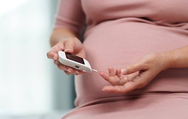 pregnant woman at prenatal appointment discussing gestational diabetes screening and blood sugar monitoring