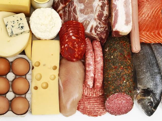Saturated fat in foods — coconut oil, processed meat, and dairy products on a table