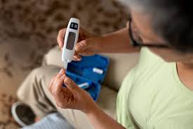 selection of blood glucose monitors including traditional fingerstick meters and a continuous glucose monitor on a table