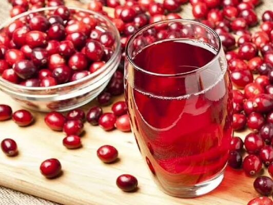 cranberry and urinary tract health — glass of cranberry juice with fresh cranberries showing natural UTI prevention approach