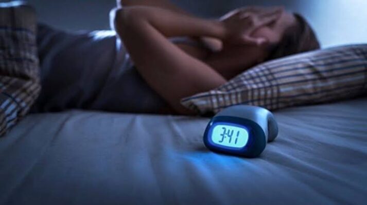 diabetes and sleep — adult checking glucose monitor before bedtime