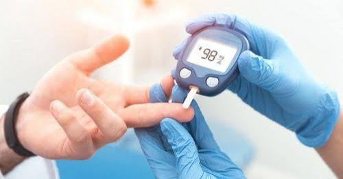diabetes burnout — adult sitting exhausted, glucose meter untouched on table