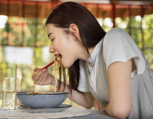 Person eating slowly and mindfully at a table, demonstrating proper chewing and relaxed meal pace for digestive health