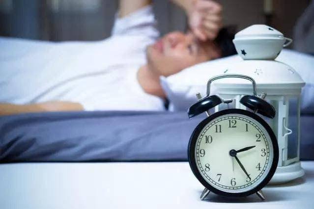 kidney disease and sleep problems — CKD patient experiencing sleep disturbance with clock showing nighttime hours from uremic sleep disruption