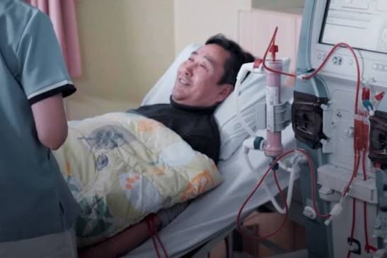 life on dialysis what to expect — home peritoneal dialysis patient connecting to APD cycler machine before sleeping