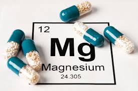 magnesium supplement capsules next to magnesium-rich foods including nuts, seeds, and leafy greens