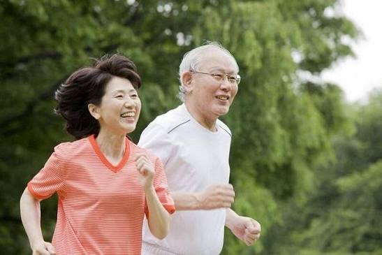 safe exercise with diabetes — middle-aged adult with diabetes wearing proper athletic shoes and a continuous glucose monitor on their arm walking on a paved trail in a park setting
