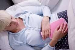 Person sleeping peacefully in a dark room showing the importance of quality sleep for digestive health, gut microbiome, intestinal permeability and IBS symptoms
