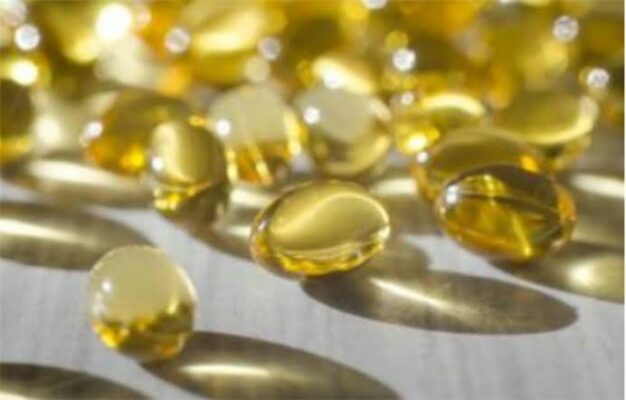 vitamin D supplement capsules next to sunlight streaming through a window representing sun-based vitamin D production