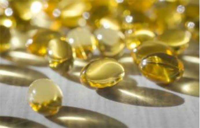vitamin D supplement capsules next to sunlight streaming through a window representing sun-based vitamin D production