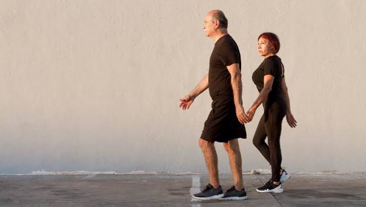 Person taking a gentle walk outdoors after a meal showing benefits of post-meal walking for digestion and blood glucose management