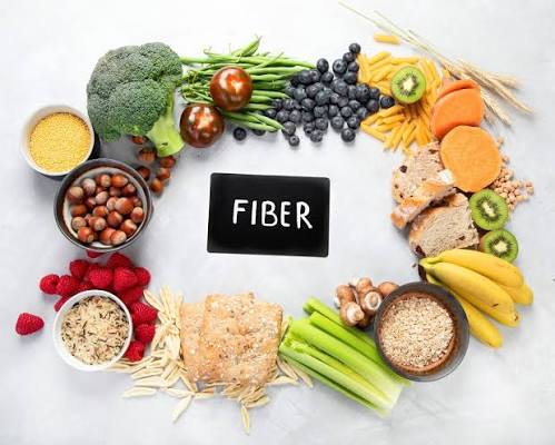 Fiber supplement products including psyllium husk powder, methylcellulose capsules, and inulin powder displayed on a kitchen counter, illustrating the range of fiber supplement types available