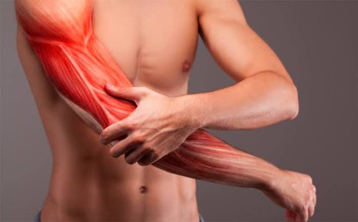 Muscle stiffness causes and prevention — person stretching and massaging sore muscles after exercise