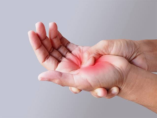 Hand and wrist pain possible causes — person holding wrist in pain suggesting carpal tunnel syndrome or De Quervain's tenosynovitis